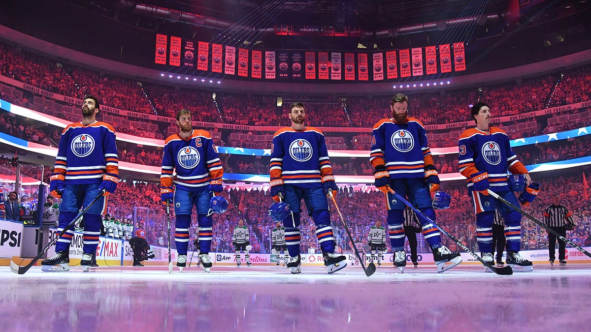 Oilers players stand for the national anthem