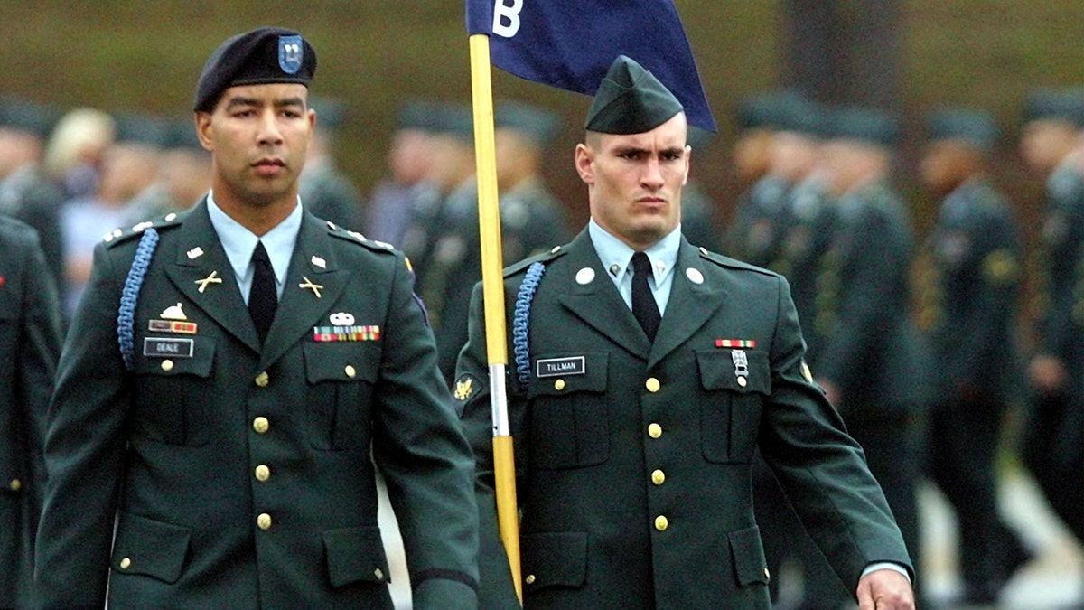 Pat Tillman walks next to Captain Christopher Deale in Army gear