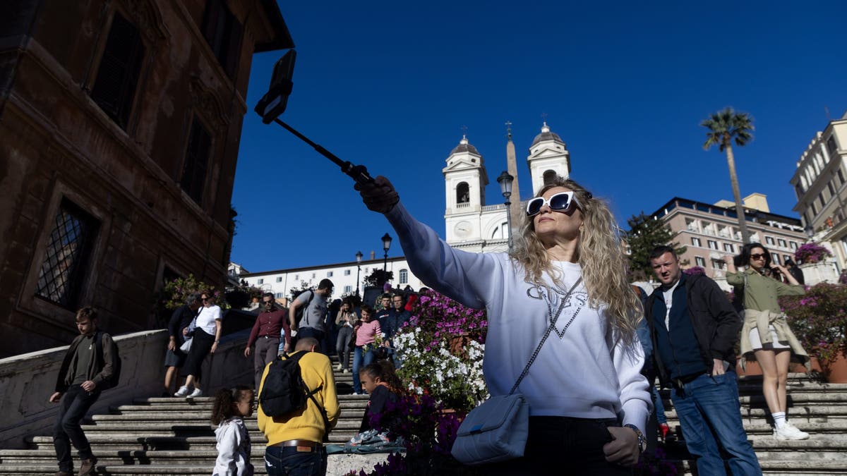 Girl on trip in Italy taking a selfie with a selfie stick