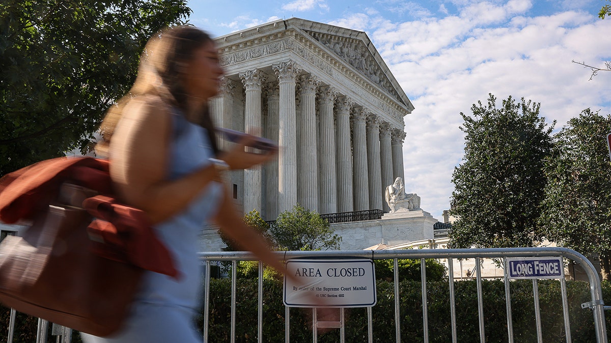 Woman walks past Supreme Court building