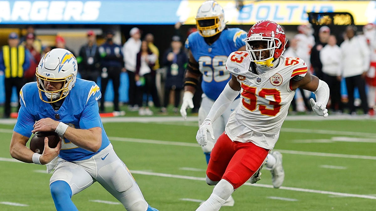 Kansas City Chiefs' B.J. Thompson chases Easton Stick, #2 of the Los Angeles Chargers, in the fourth quarter during a game against the Kansas City Chiefs at SoFi Stadium on January 7, 2024, in Inglewood, California.