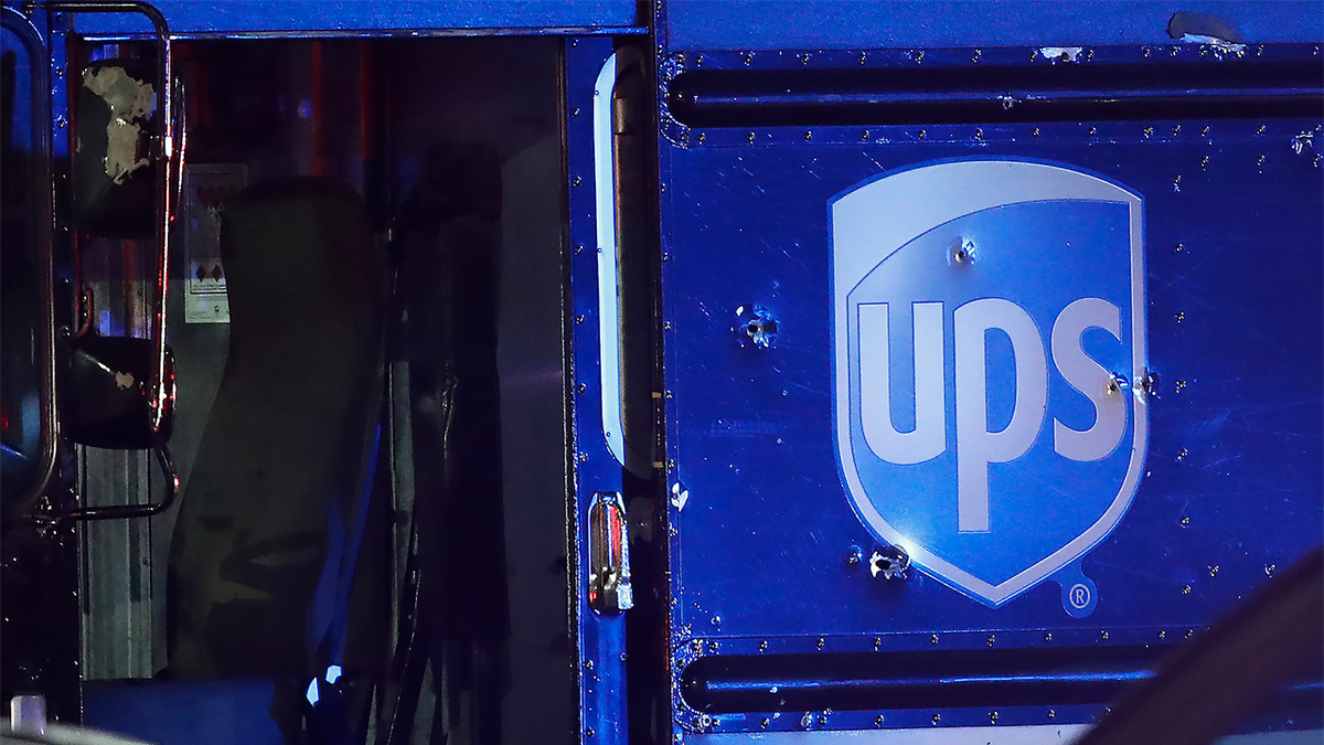 Bullet holes are seen around the UPS logo on a van at the scene of a shooting