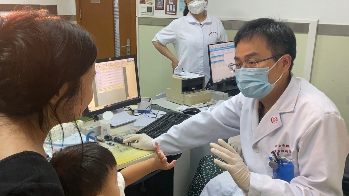 Dr. Yilai Shu communicates with a young patient at the Eye ENT Hospital of Fudan University