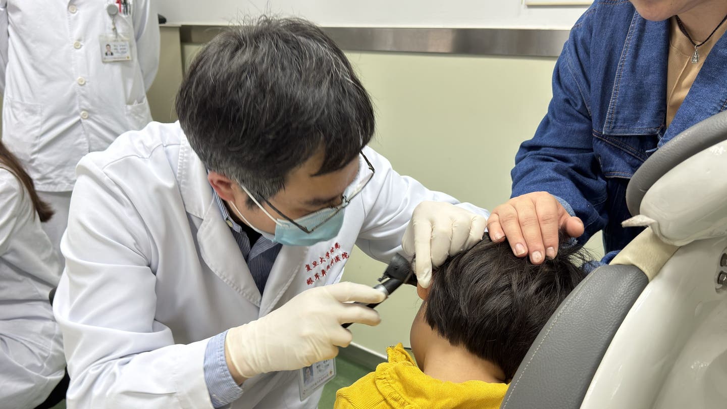 Dr. Yilai Shu examines a young patient at the Eye ENT Hospital of Fudan University scaled