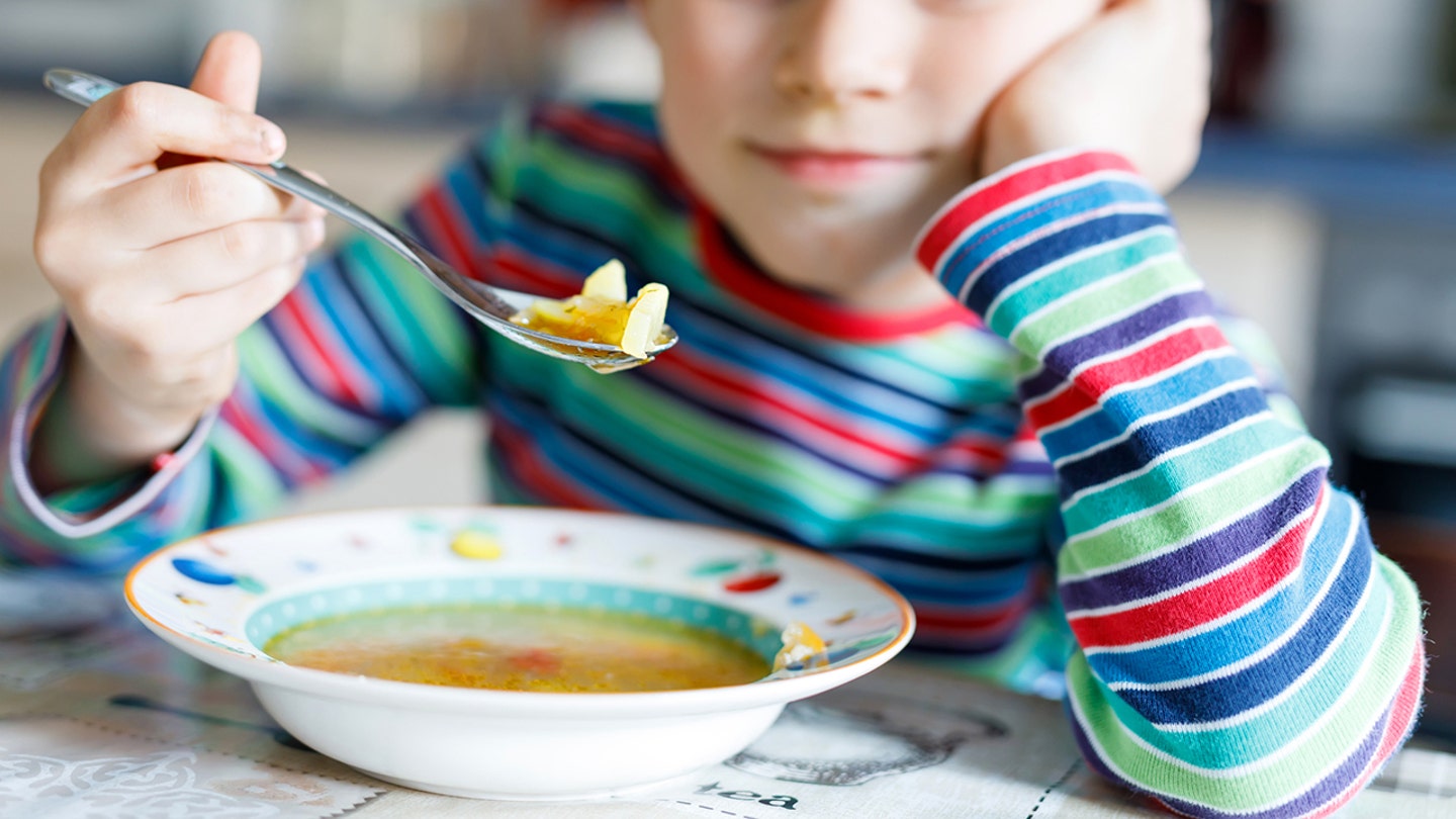 little boy eating soup
