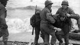 Unidentified survivors from a sunken LCVP (landing craft, vehicle, personnel, also known as a Higgins boat) are helped ashore at Omaha Beach during the invasion of Normandy, Normandy, France, June 6, 1944. (Photo by Underwood Archives/Getty Images)