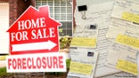 Home for sale due to foreclosure sign next to photo of returned checks and a lawsuit