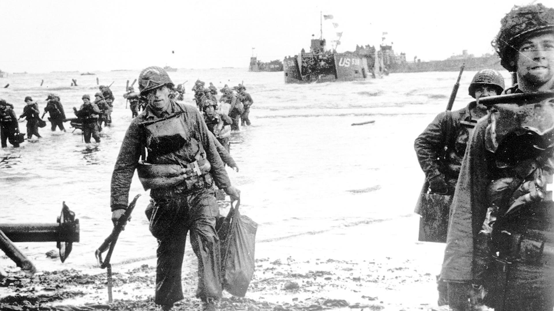 Carrying full equipment, American assault troops move onto a beachhead code-named Omaha Beach