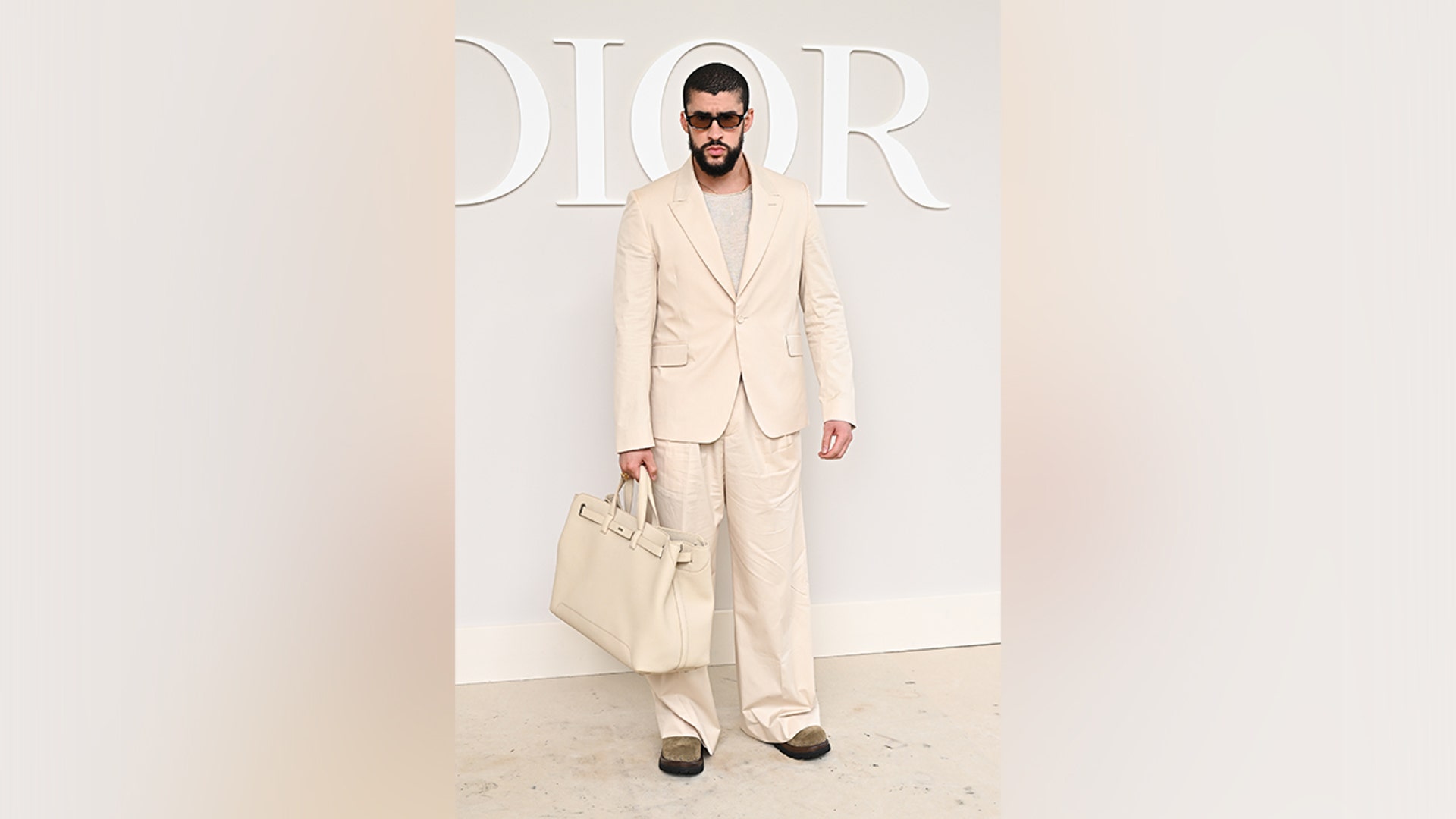 Bad Bunny wore a cream colored suit to the Dior fashion show.