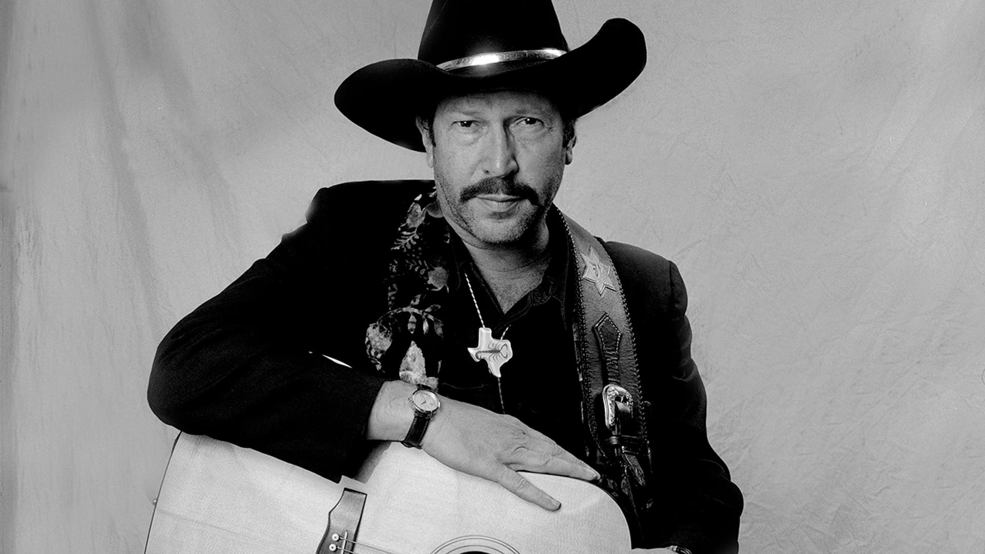 Kinky Friedman posing with his guitar