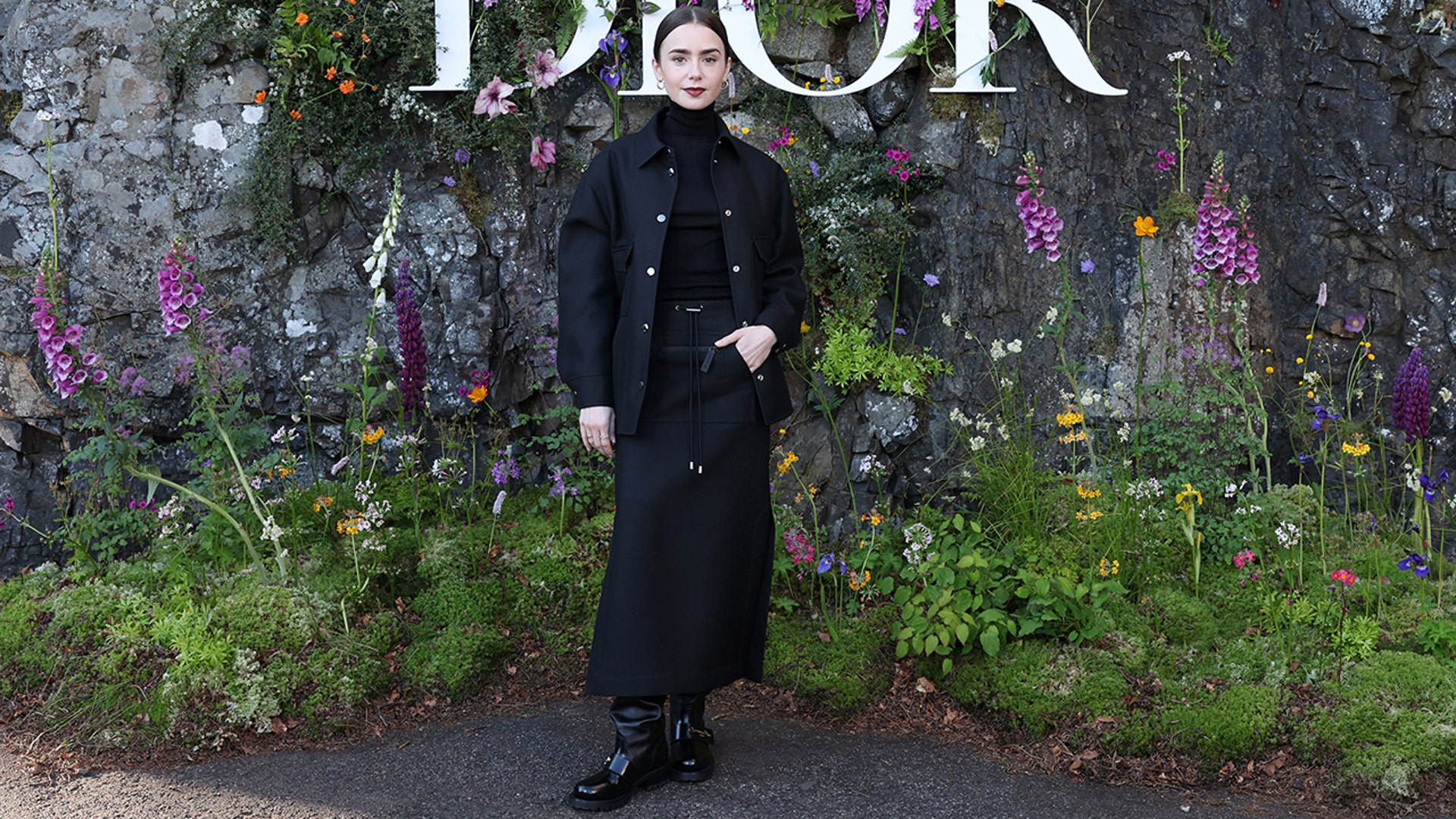 Lilly Collins at the Dior fashion show wearing black from head to toe.