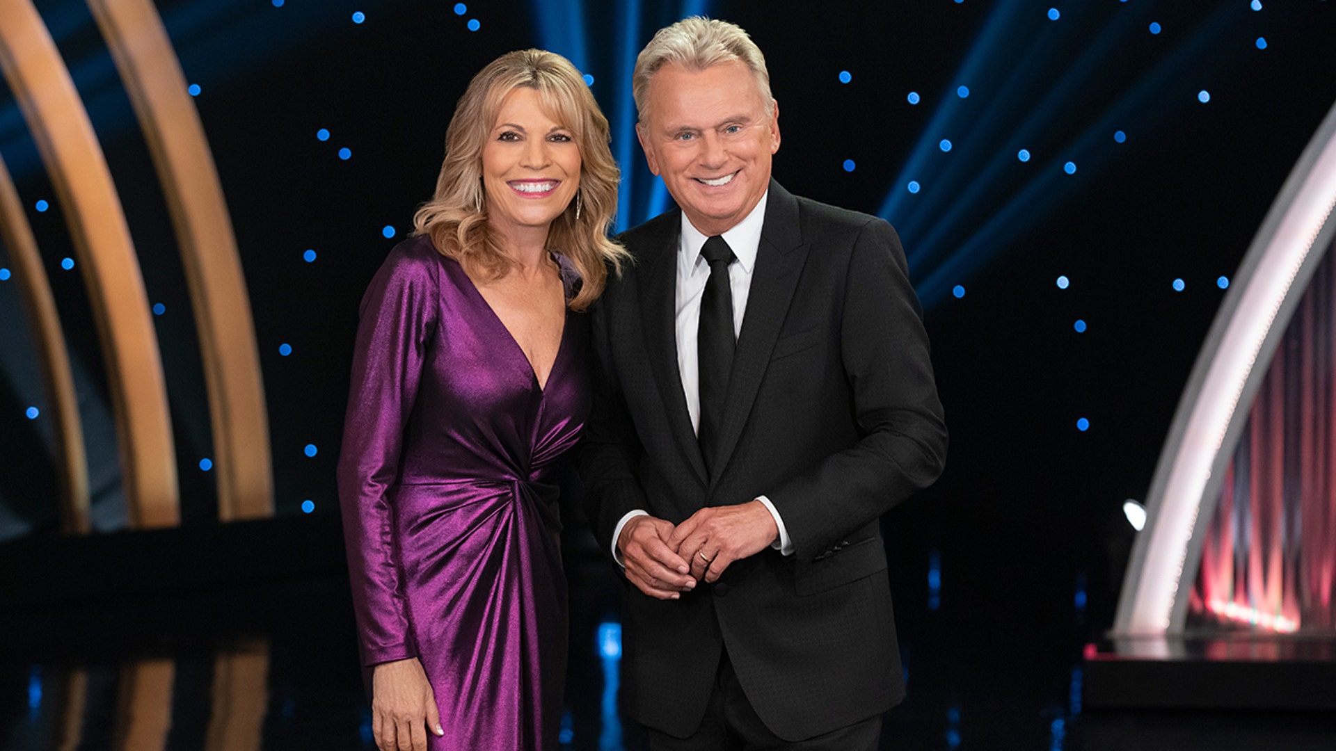 Pat Sajak and Vanna White wearing purple and black