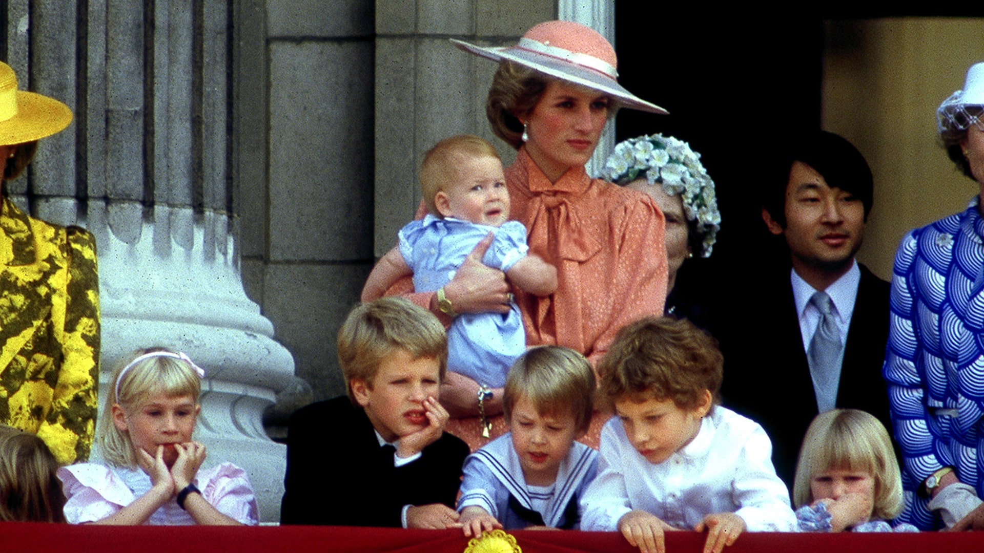 Princess Diana often stood near with the royal children. She can be seen here holding baby Prince Harry, and standing behind Prince William.
