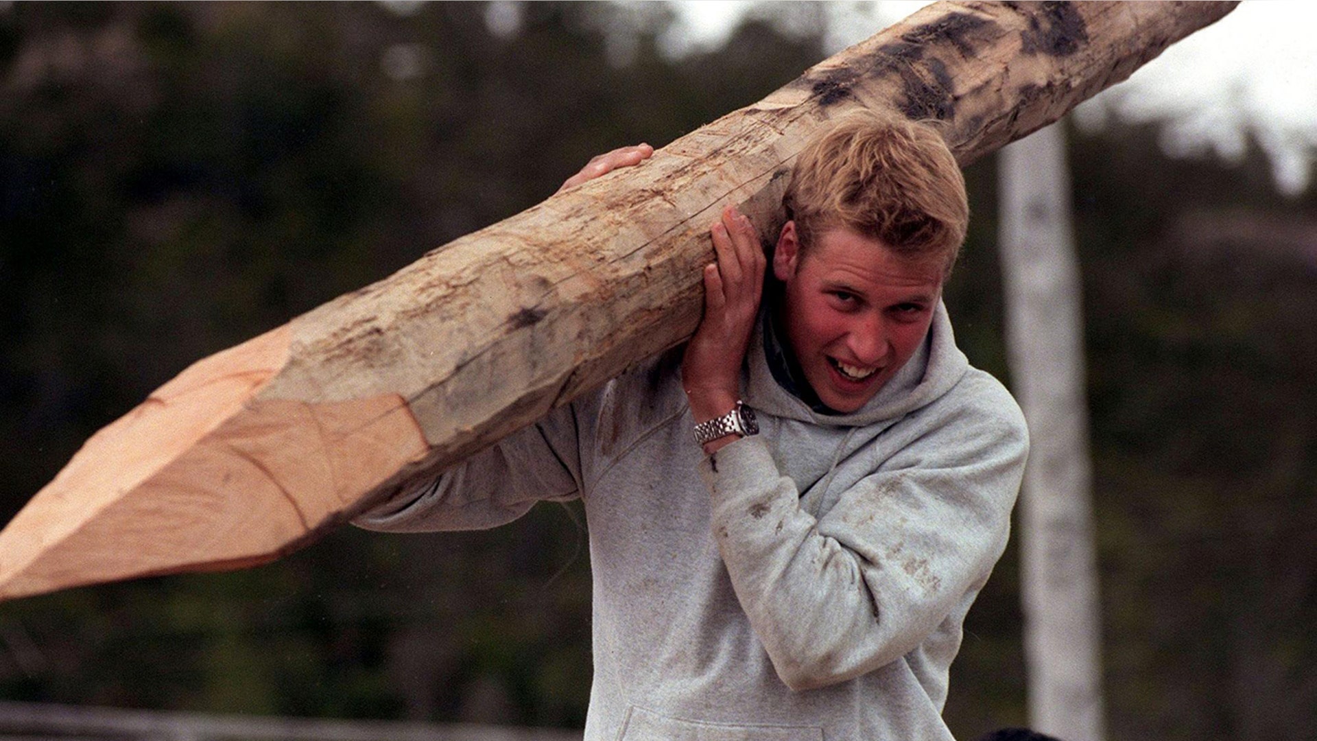 Prince William carrying a big log.