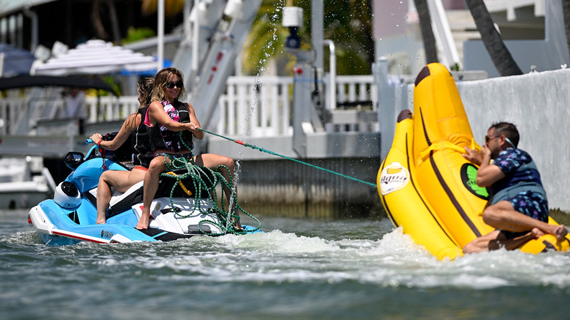 Sydney Sweeney on the back of a jet ski, pulling a rope