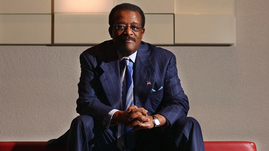 Lawyer Johnnie Cochran wears blue suit at speaking engagement.