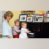 Princess Diana sits with her two boys in front of the piano in their Kensington Palace home.
