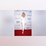 Donna Mills in a white suit on the red carpet.