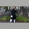 Rosamund Pike wore a long black trench coat and white trousers when attending the Dior fashion show in Scotland.