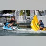 Sydney Sweeney on the back of a jet ski, pulling a rope