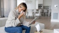 Sick woman blowing her nose while talking to her doctor on a video call -  telemedicine concepts - Fox News