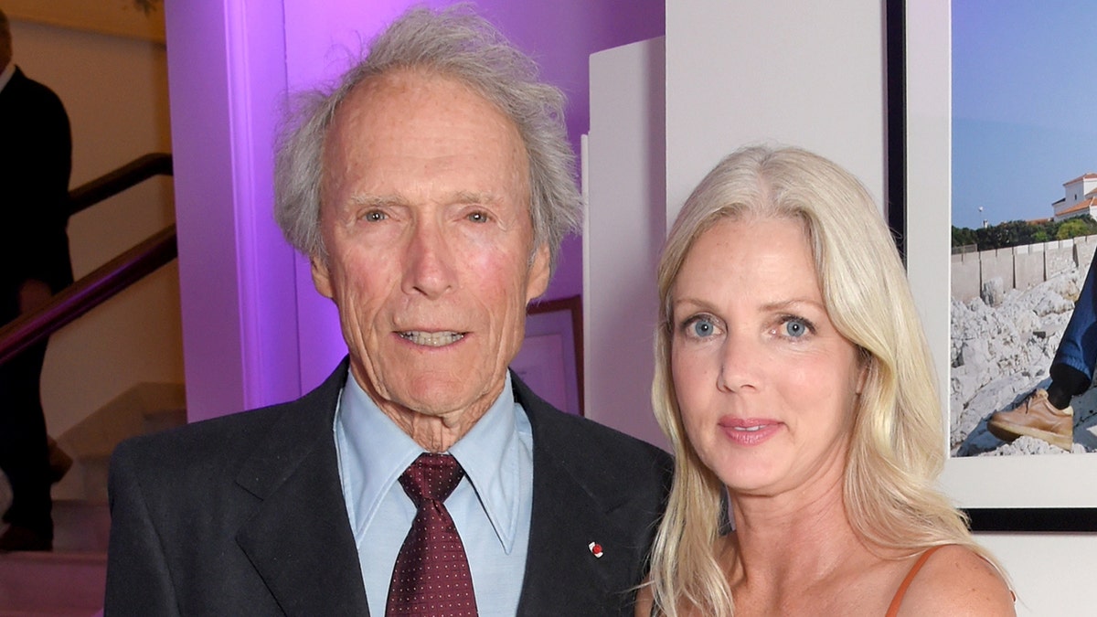 Clint Eastwood wears blue suit on red carpet with Christina Sandera.