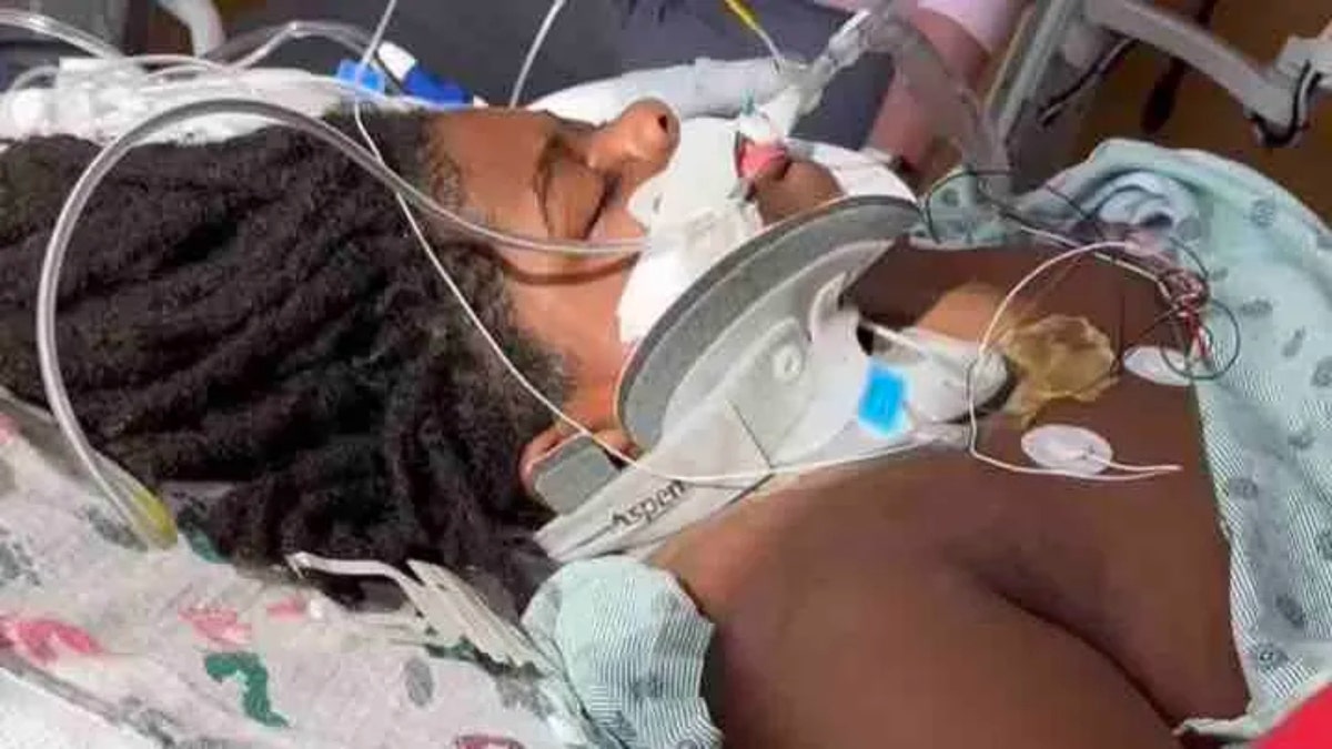 SJ Williams in a hospital bed with tubes hooked up to his face