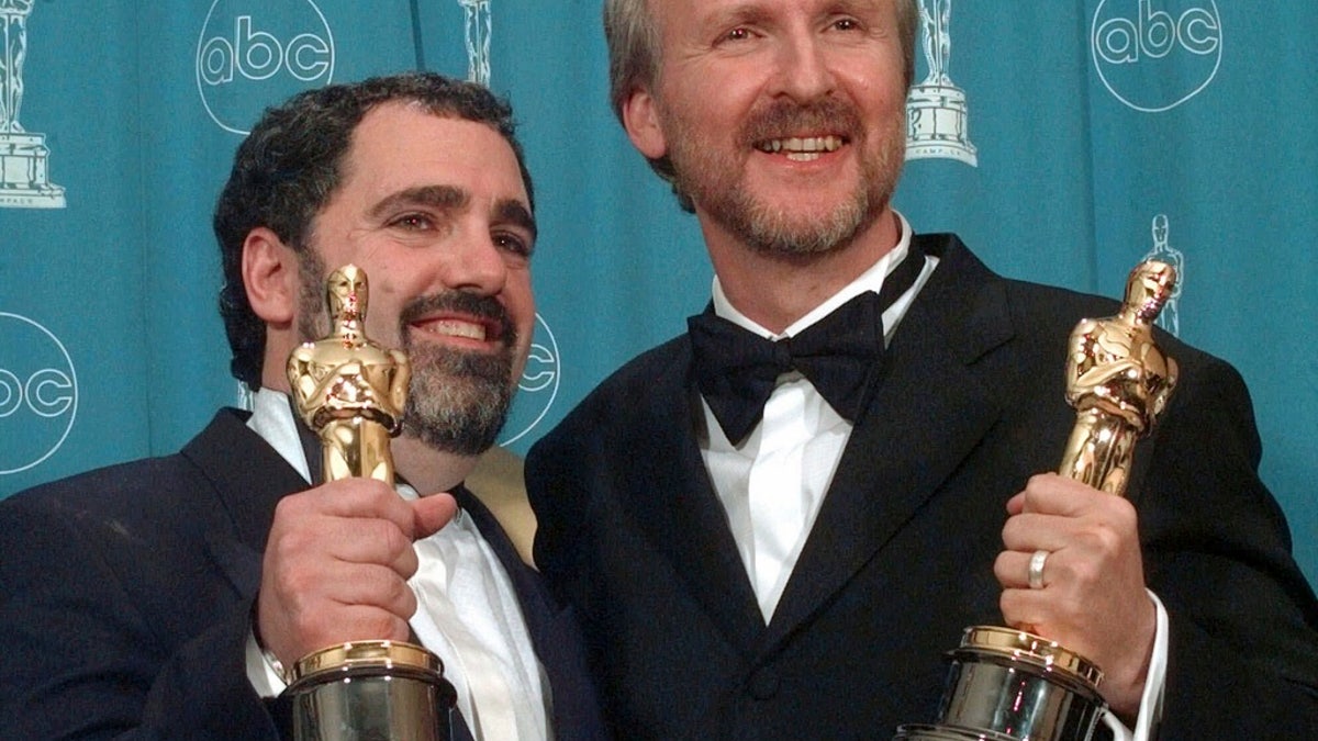 James Cameron, right, and Jon Landau hold the Oscars for Best Picture for the film "Titanic" at the 70th annual Academy Awards at the Shrine Auditorium in Los Angeles, March 23, 1998.
