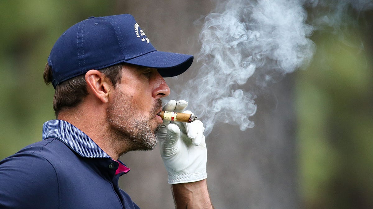 Aaron Rodgers puffs on a cigar