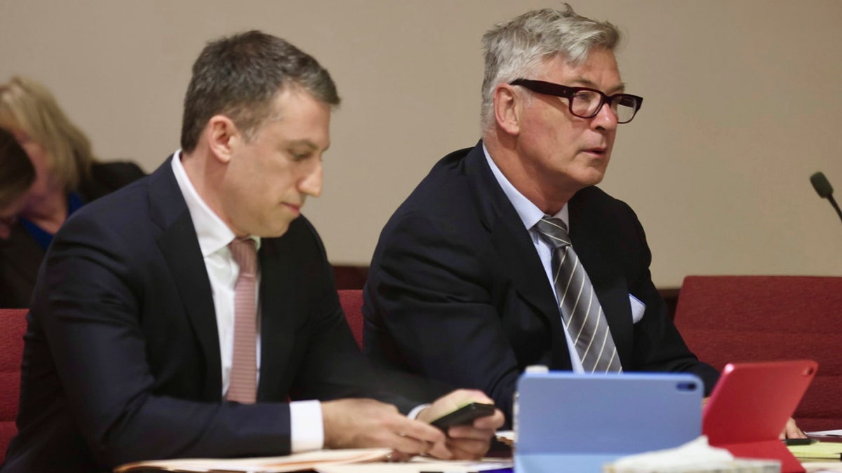 Alec Baldwin, center, sits between his attorneys in a First Judicial District courtroom