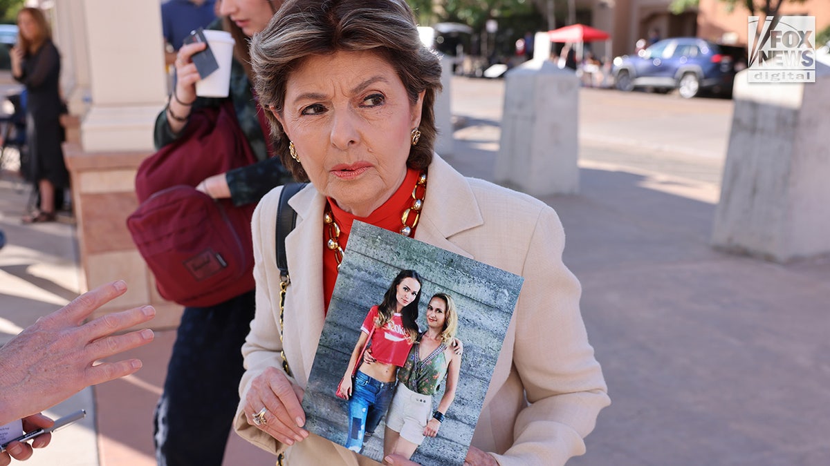 Attorney Gloria Allred holds a picture of Halyna Hutchins outside of the First Judicial District Court in Santa Fe, New Mexico