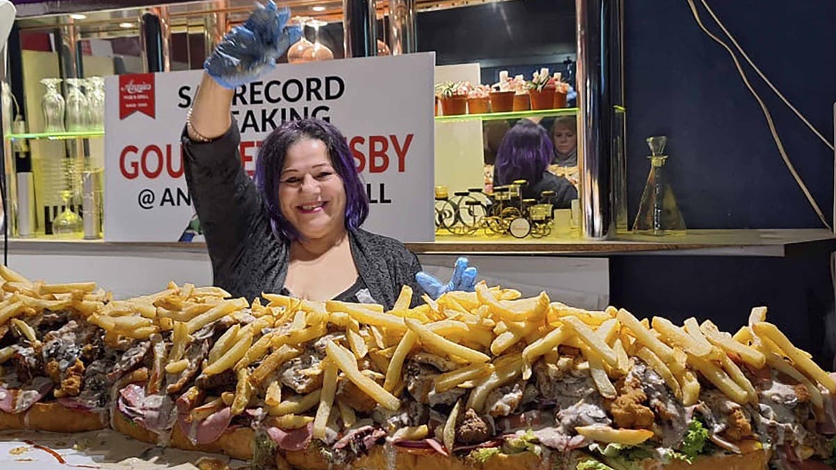 Annie Redelinghuys posa con un submarino gigante de Gatsby en el Annie's Ladies Bar de Ciudad del Cabo, Sudáfrica.