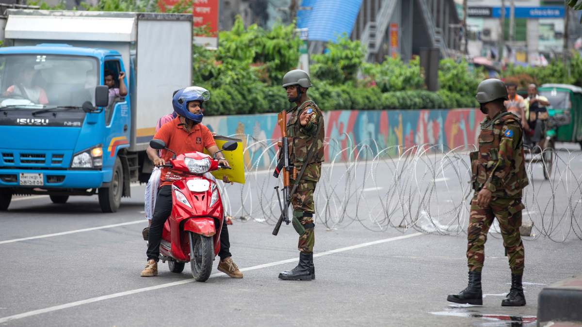 Un scooterista habla a los soldados de las fuerzas armadas de Bangladesh