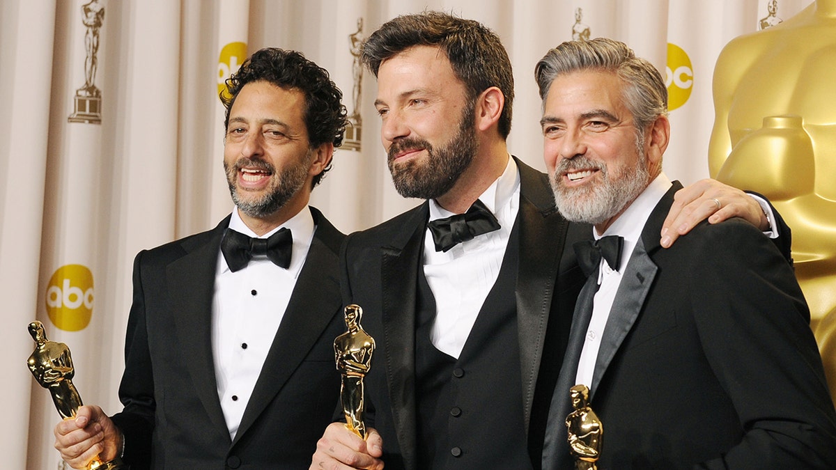 Grant Heslov, Ben Affleck, and George Clooney posing together with their Oscars