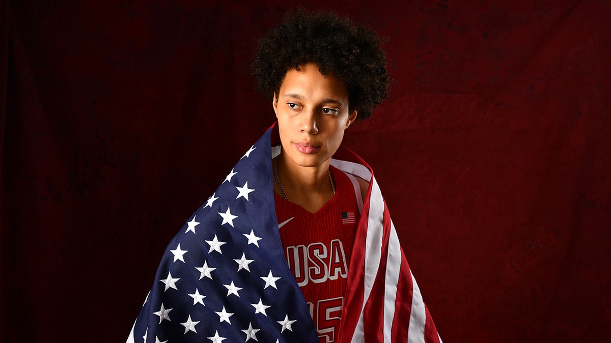 Brittney Griner with American flag wrapped around her