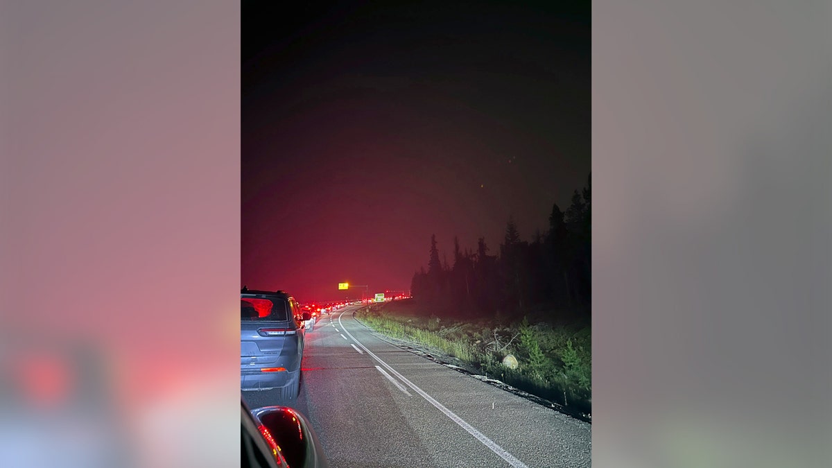 Cars clog the roadway in the early morning hours of July 23, 2024, as they attempt to flee wildfire that has spread through Canada's Jasper National Park.