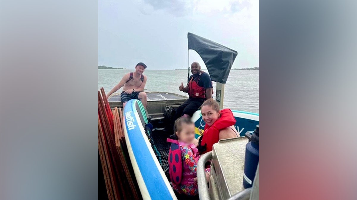 A reunited family onboard a Coast Guard boat off the coast of the Florida Keys smiles for the camera