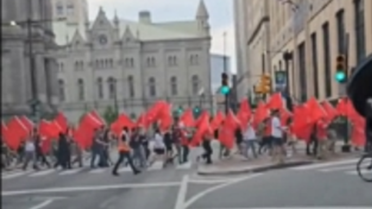 Communists march in Philadelphia, holding flags