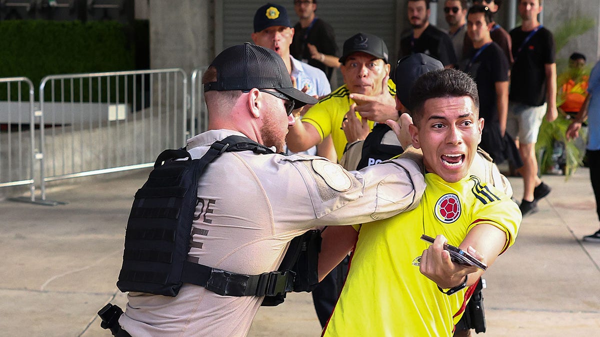Officers detain a Colombian fan