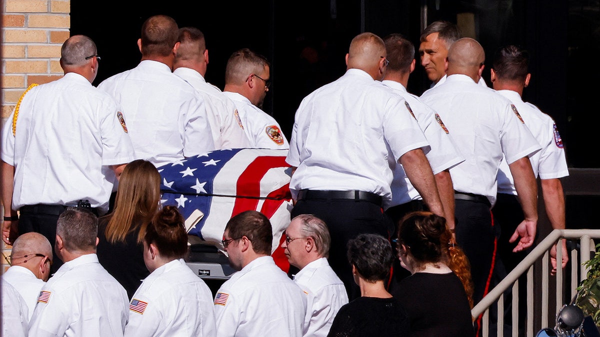 Fire fighters carry the casket of Corey Comperatore