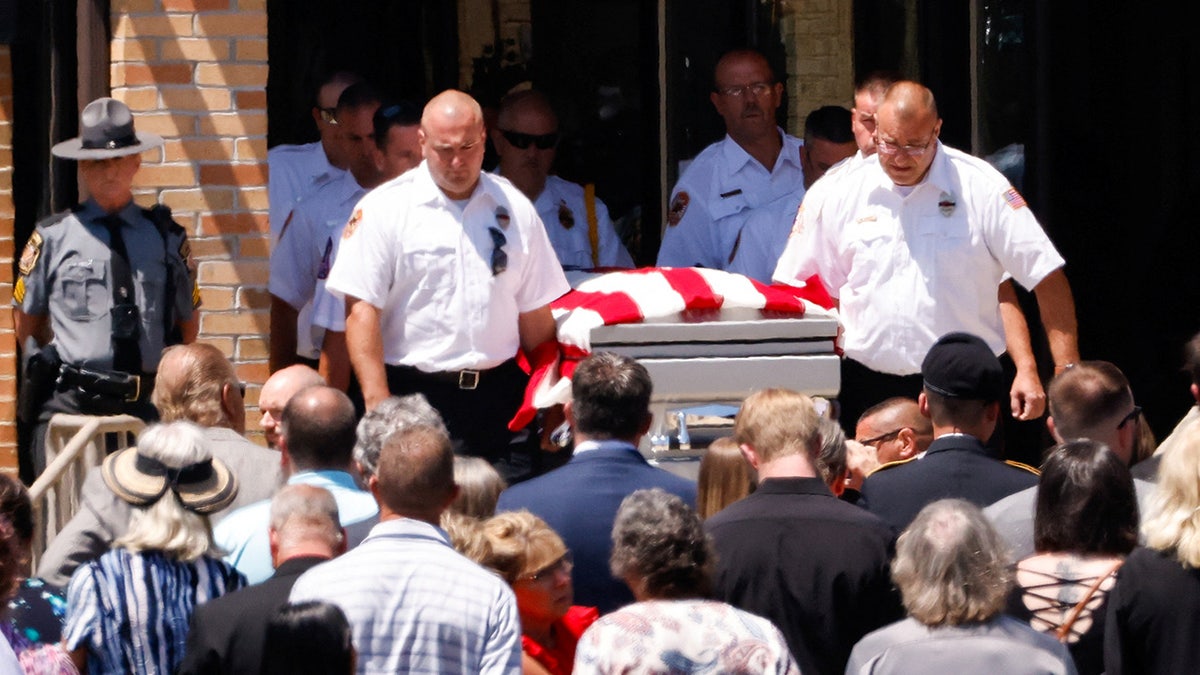 Firefighters carry Corey Compperatore's coffin