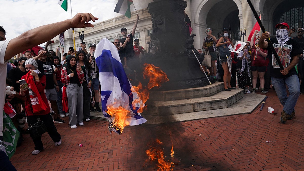 Manifestantes anti-Israel quemando una bandera israelí