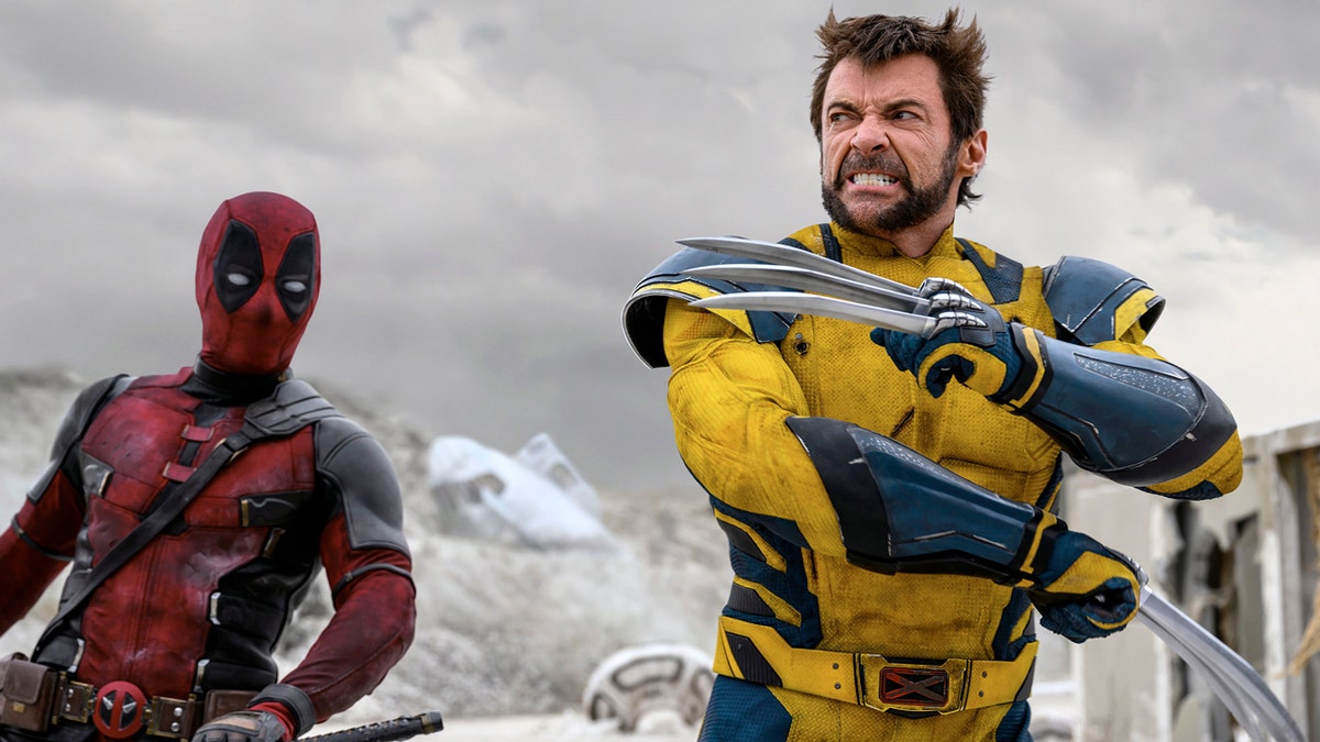 Deadpool holds his sword while Wolverine brandishes his claws in a snowy landscape.