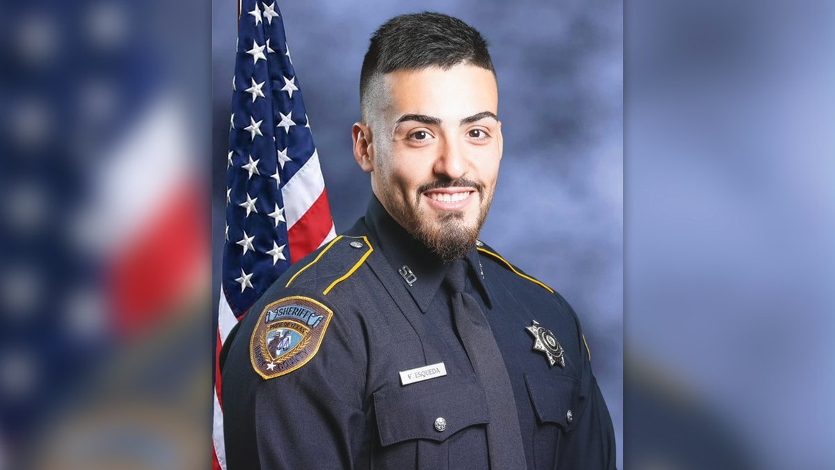 Harris County Sheriff's Deputy Fernando Esqueda in uniform in front of a US flag in this portrait in front of a blue backdrop