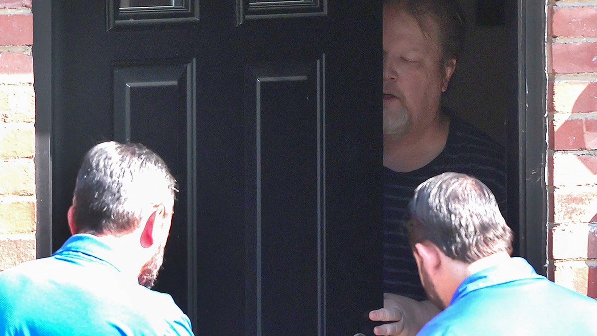 An unidentified man answers the door at the home of Thomas Matthew Crooks