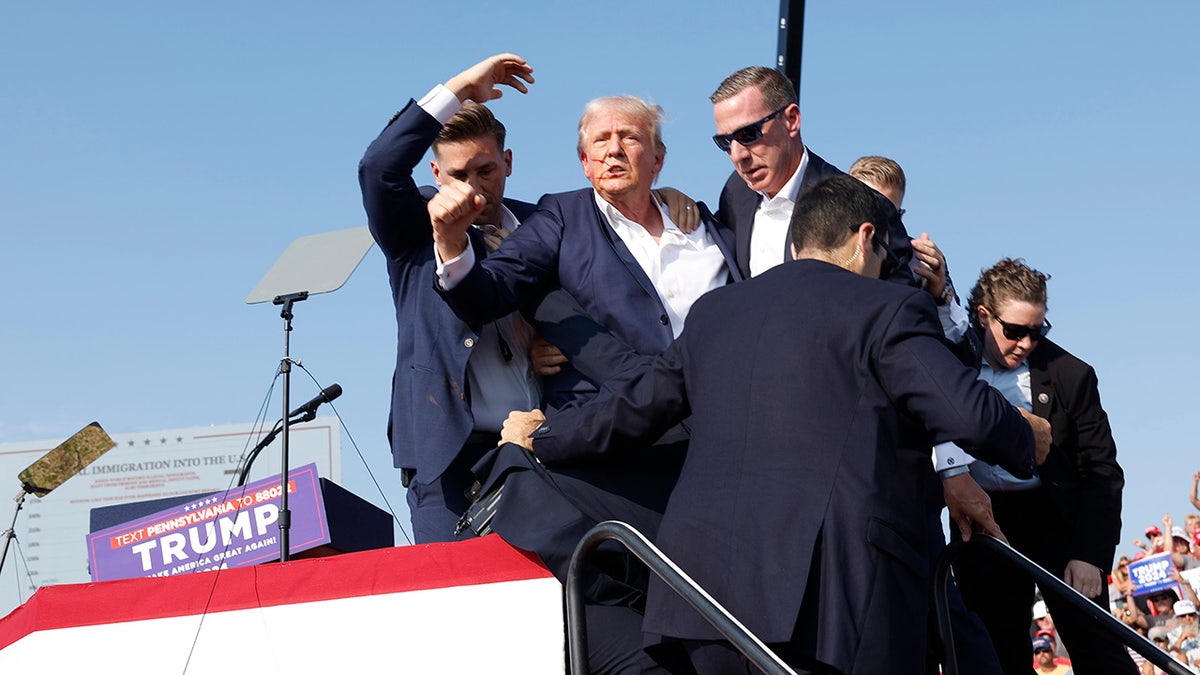 Republican presidential candidate and former President Donald Trump is pushed off the stage