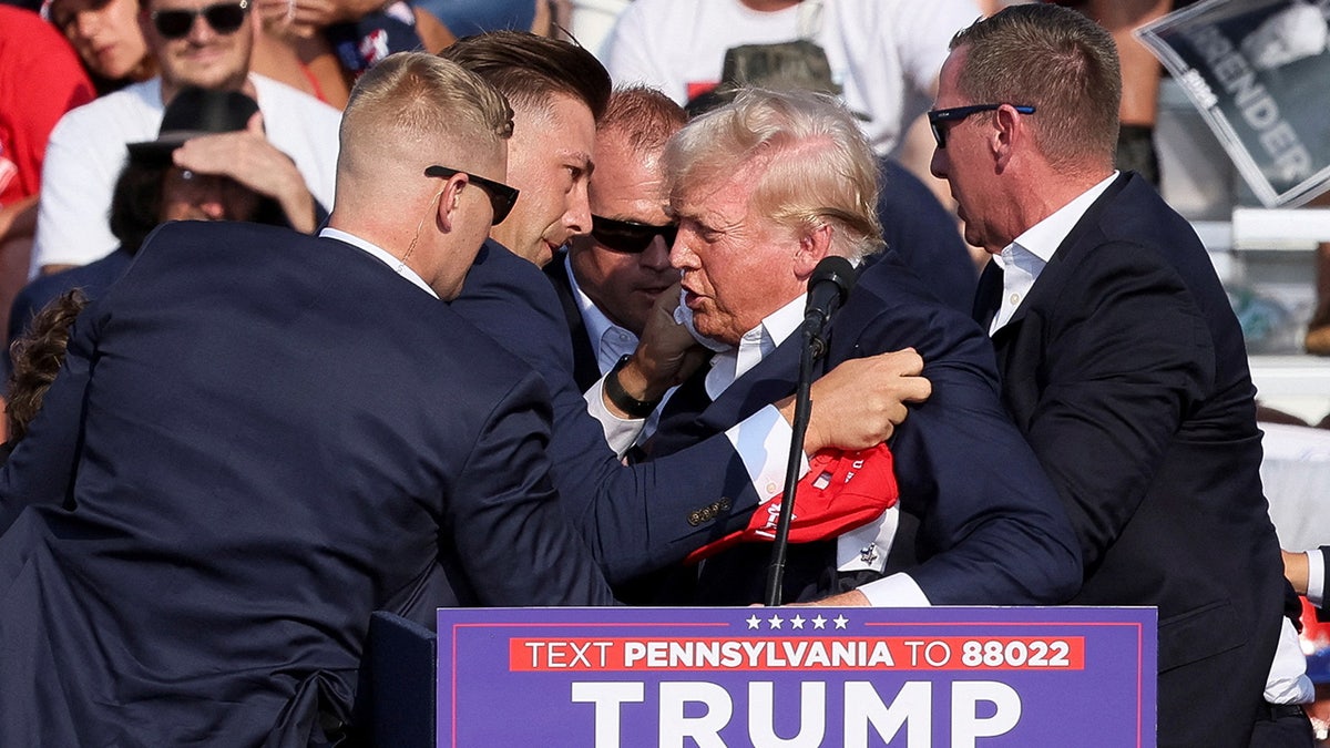 Republican presidential candidate and former U.S. President Donald Trump is assisted by guards during a campaign rally
