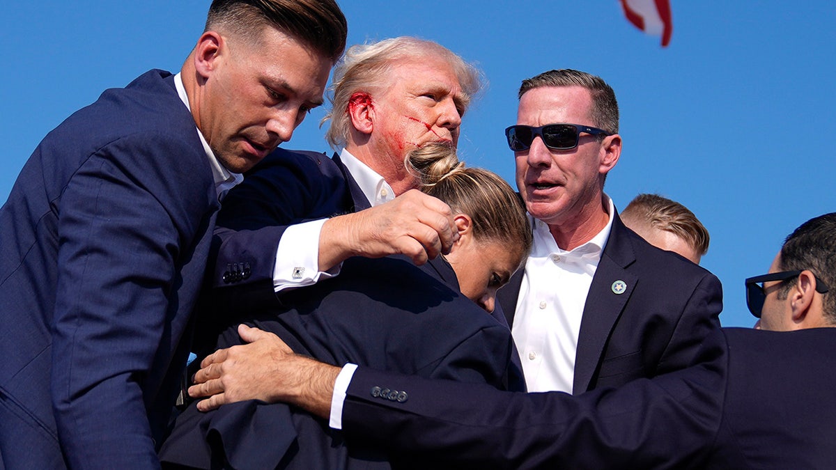 Donald Trump surrounded by US Secret Service agents at a campaign rally