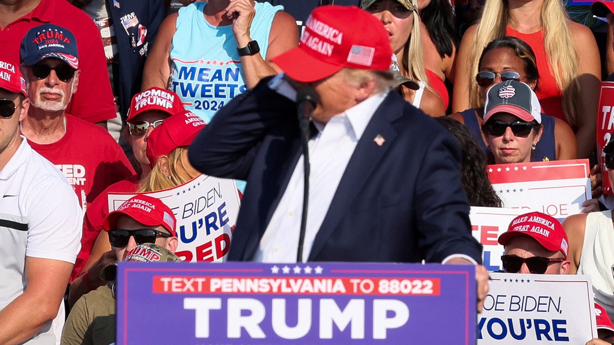 Donald Trump reacts after being shot in the ear