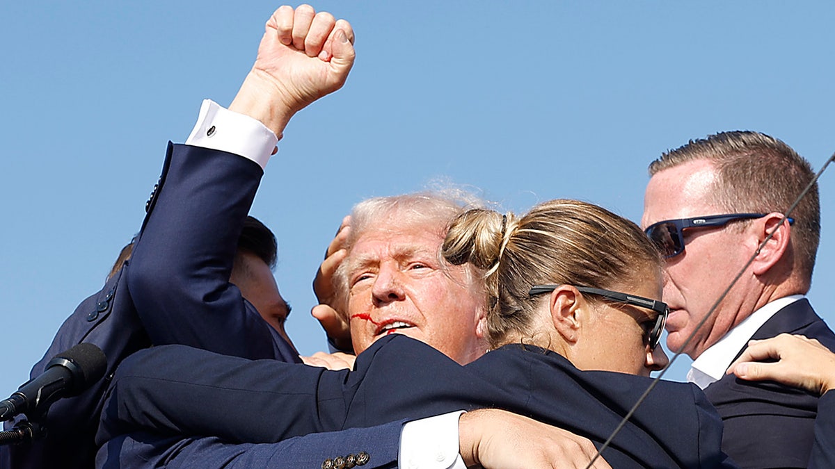 Republican presidential candidate and former President Donald Trump is quickly escorted off the stage by U.S. Secret Service agents